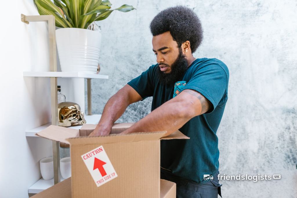 Professional mover packing fragile items into a box