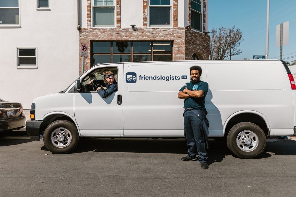 Friendly removal team standing beside their white removal van, ready for a move